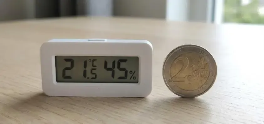 Comparativa de tamaño real: Sensor de temperatura mini junto a una moneda de 2 euros para referencia de escala