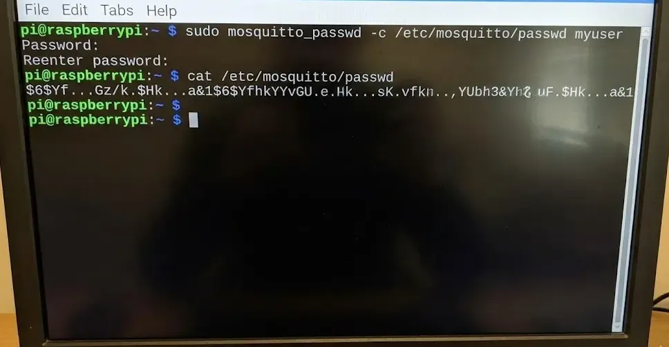 Captura de terminal Linux ejecutando el comando mosquitto_passwd para crear un usuario, mostrando el resultado del archivo con el hash de la contraseña encriptada.
